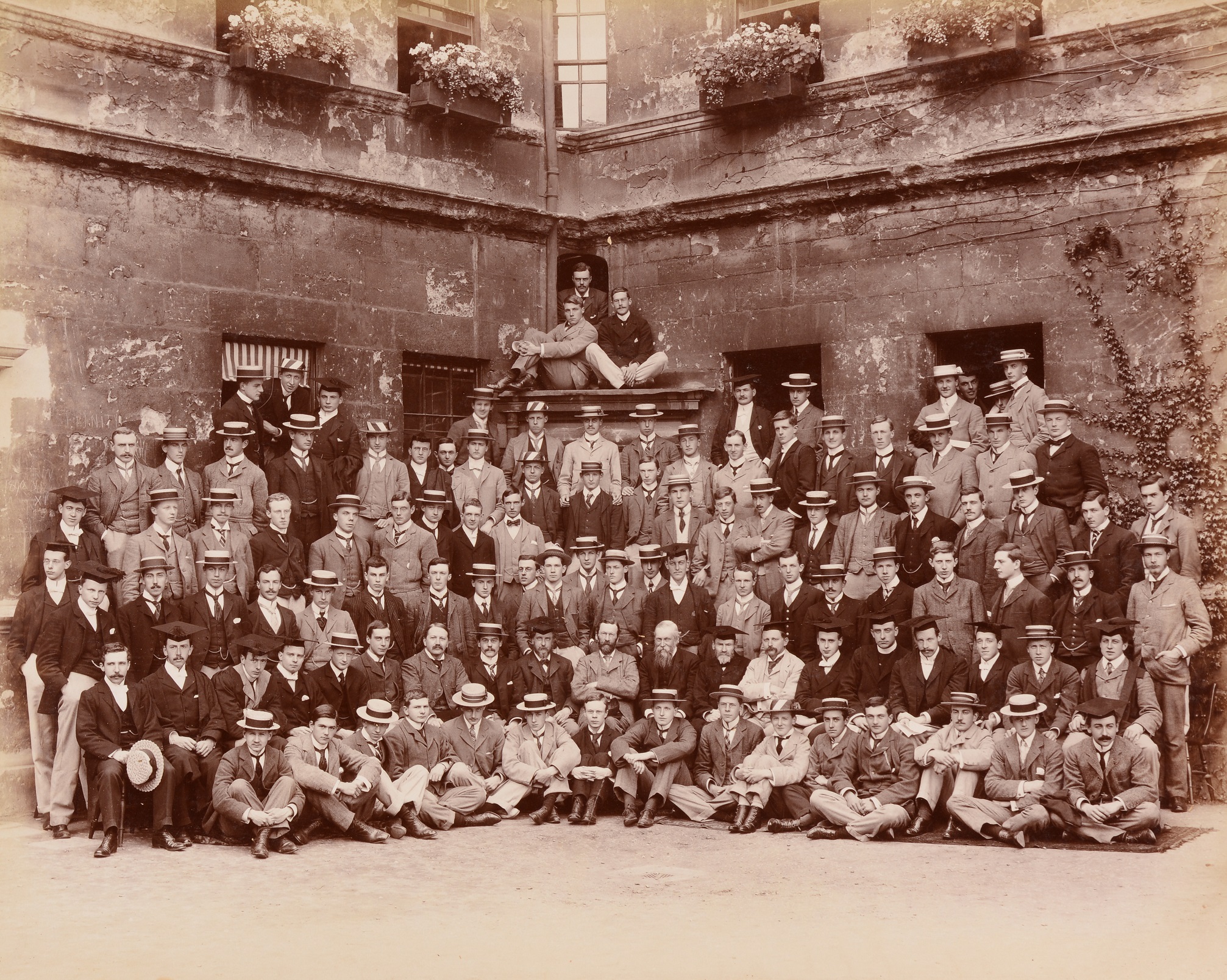 A historic photograph showing a group of Trinity College students in 1898 outside Staircase 14 in college.