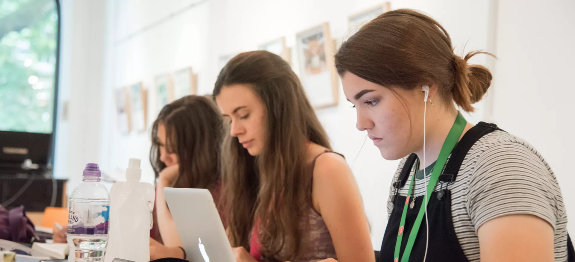 A row of female students look at their computers.