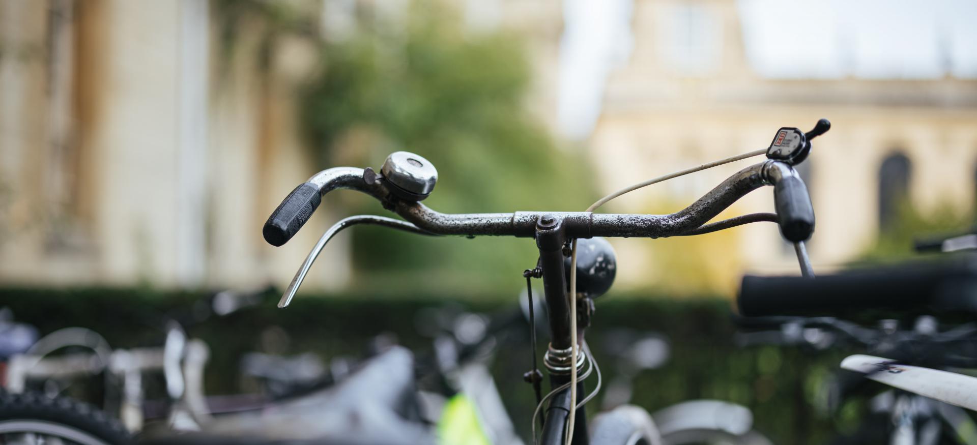 The front of a bicycle in focus, with Trinity's Chapel in the background.