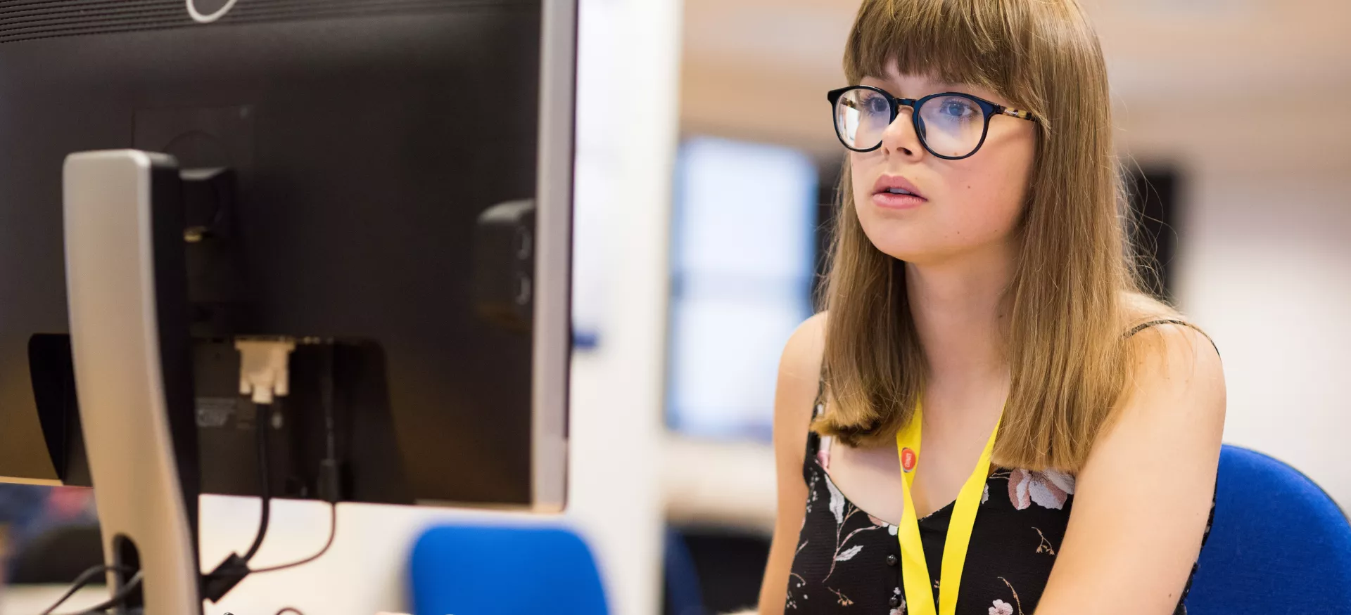 A female student sits working on a computer.