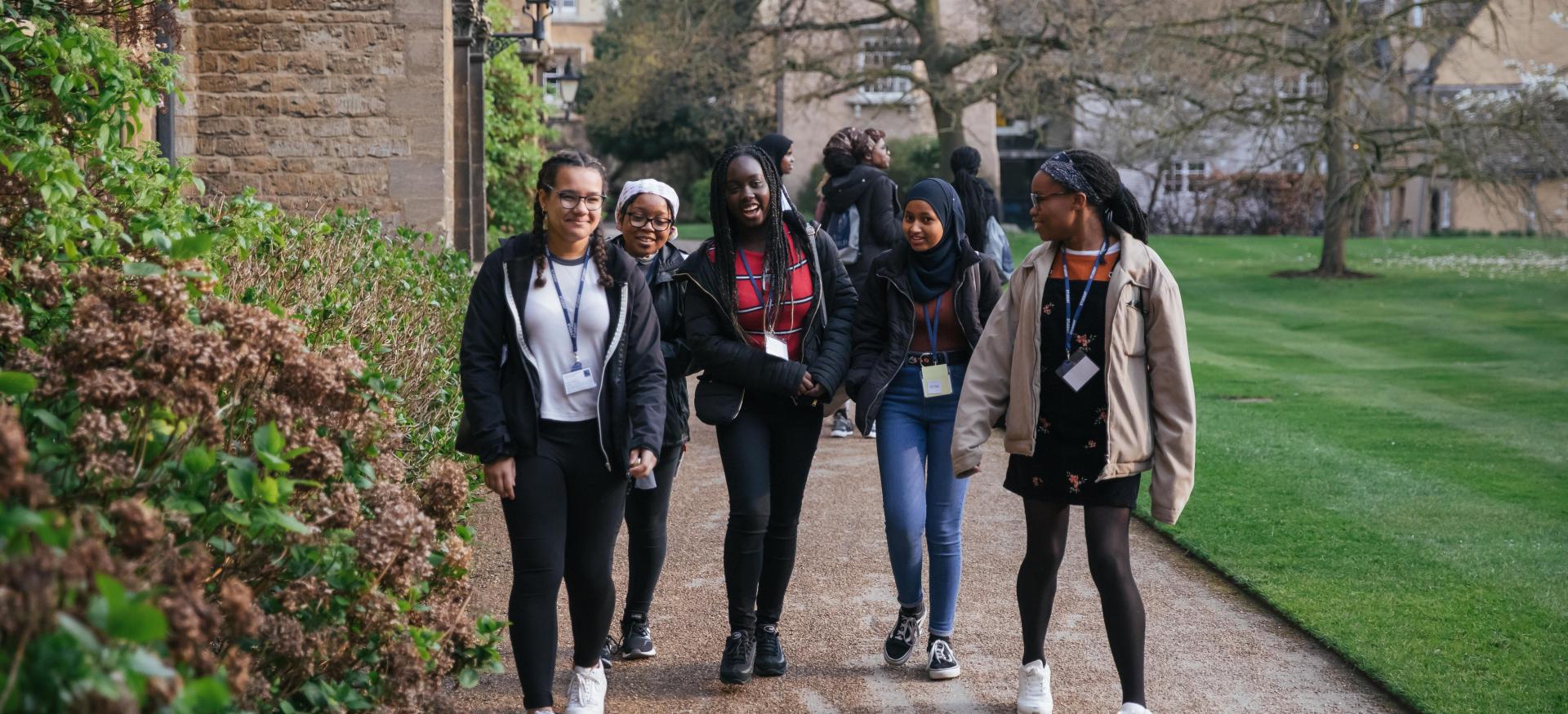 A group of secondary school students chats as they walk around Trinity College.