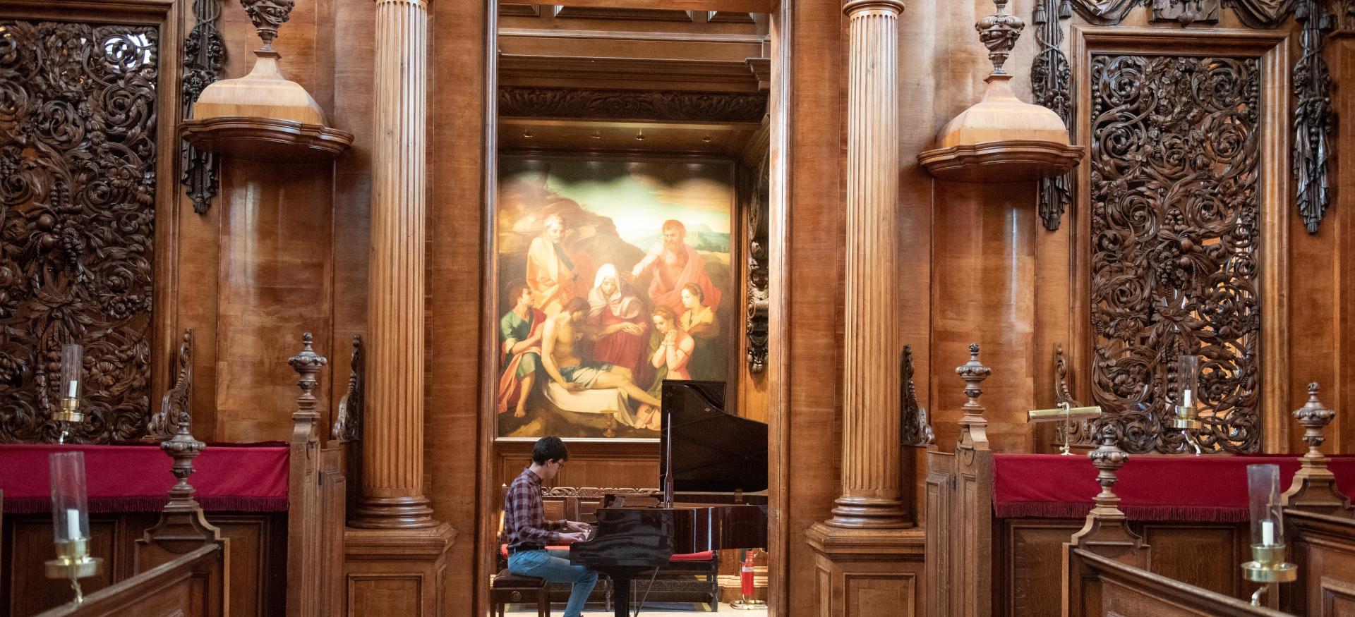 A view inside Trinity College Chapel of a student playing the piano in the Chapel.