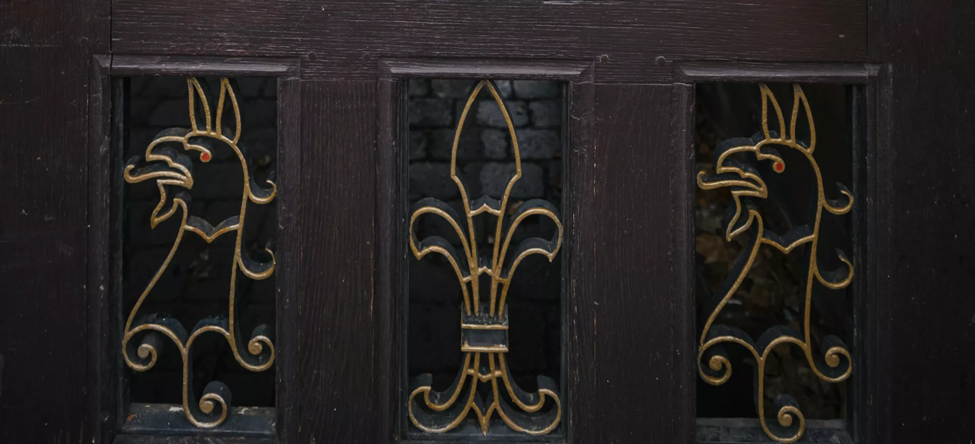 A detail from the back gate to Trinity College, with a gryphon in metal. 