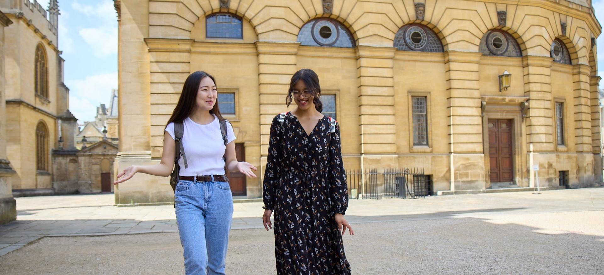Two female students walk outside. 