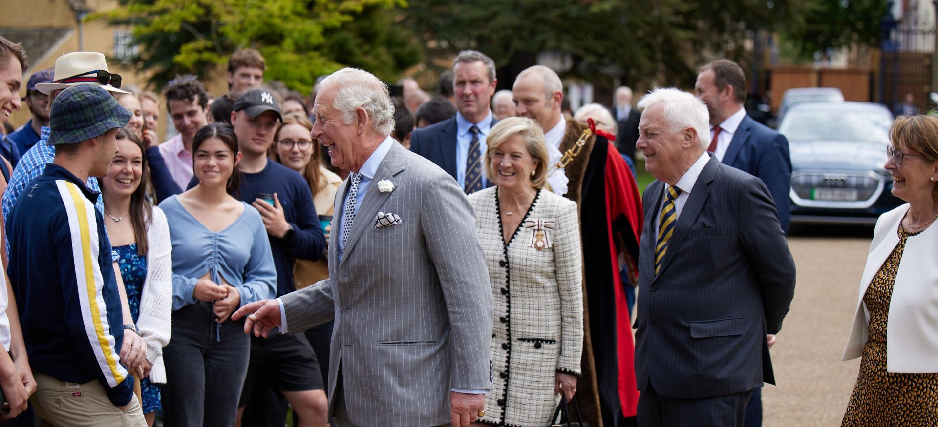 Prince Charles laughs with a student during his visit to trinity college.