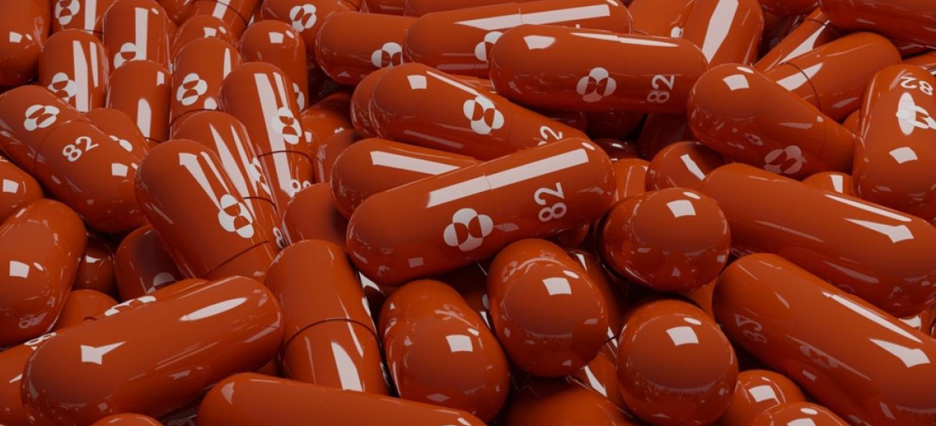 a pile of red molnupiravir capsules.