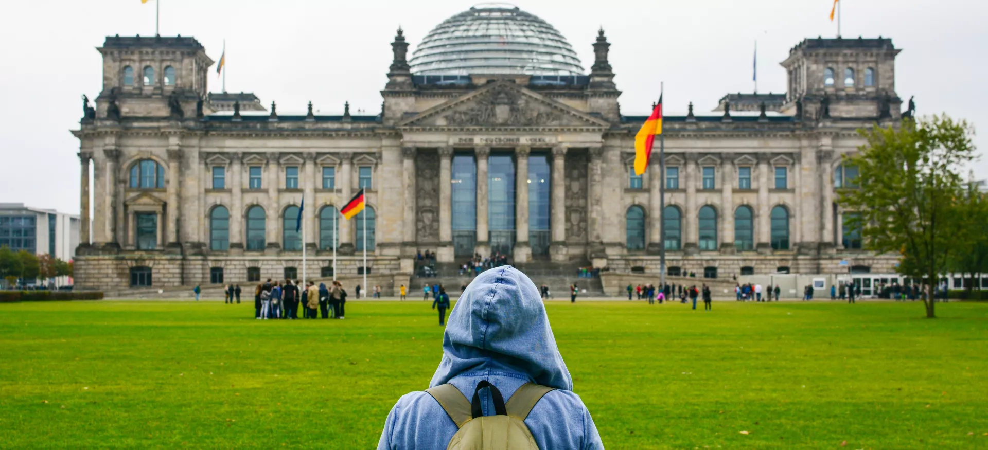 A young woman with backpack looking at Bundestag building in Berlin.