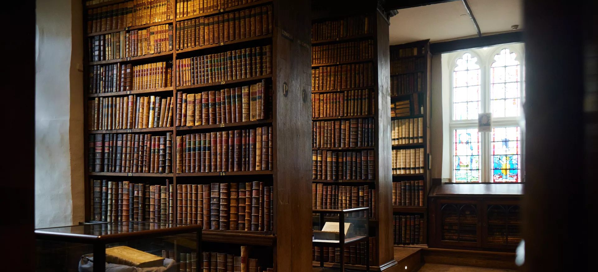 Trinity's Old Library with light shining through a stained glass window.
