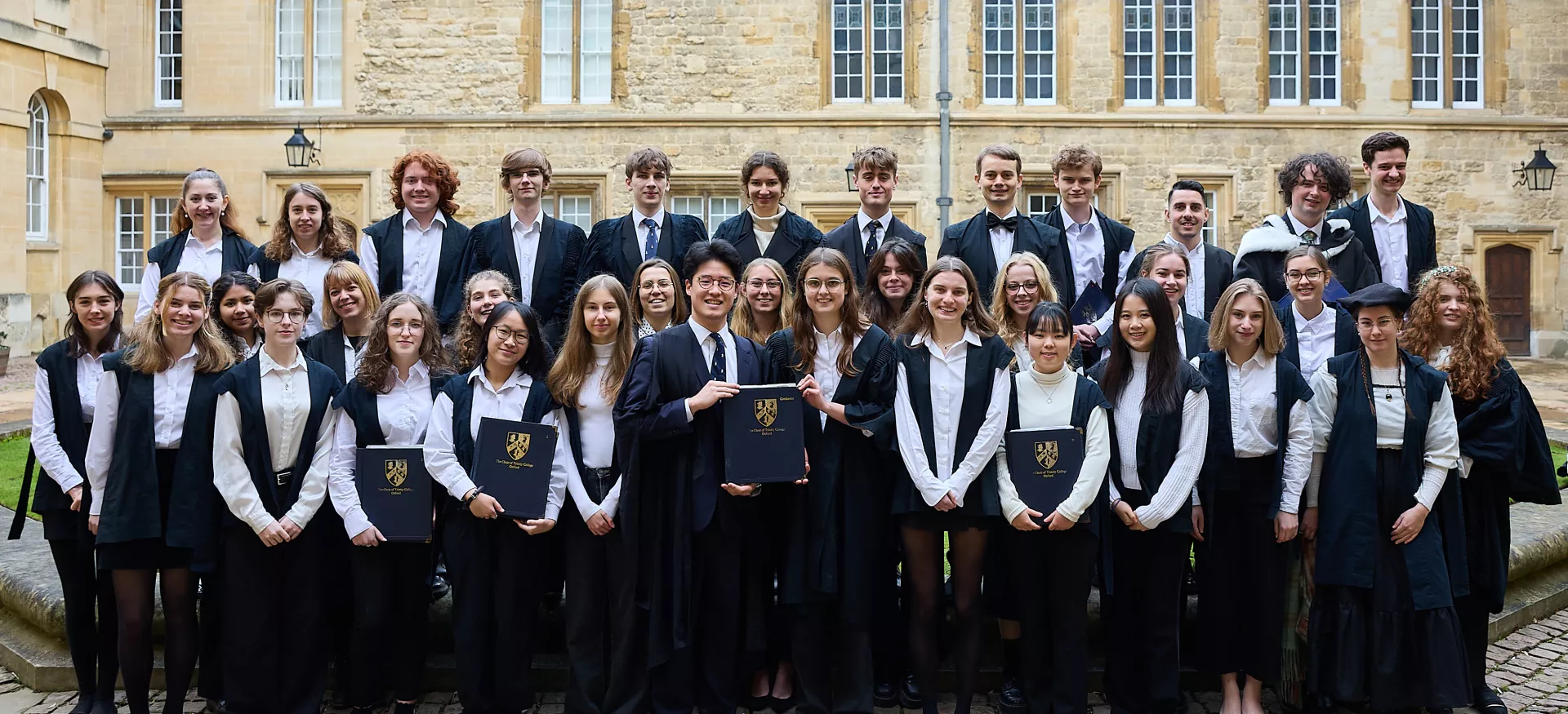 The Trinity chapel choir stand in sub fusc in the college's Durham quad.