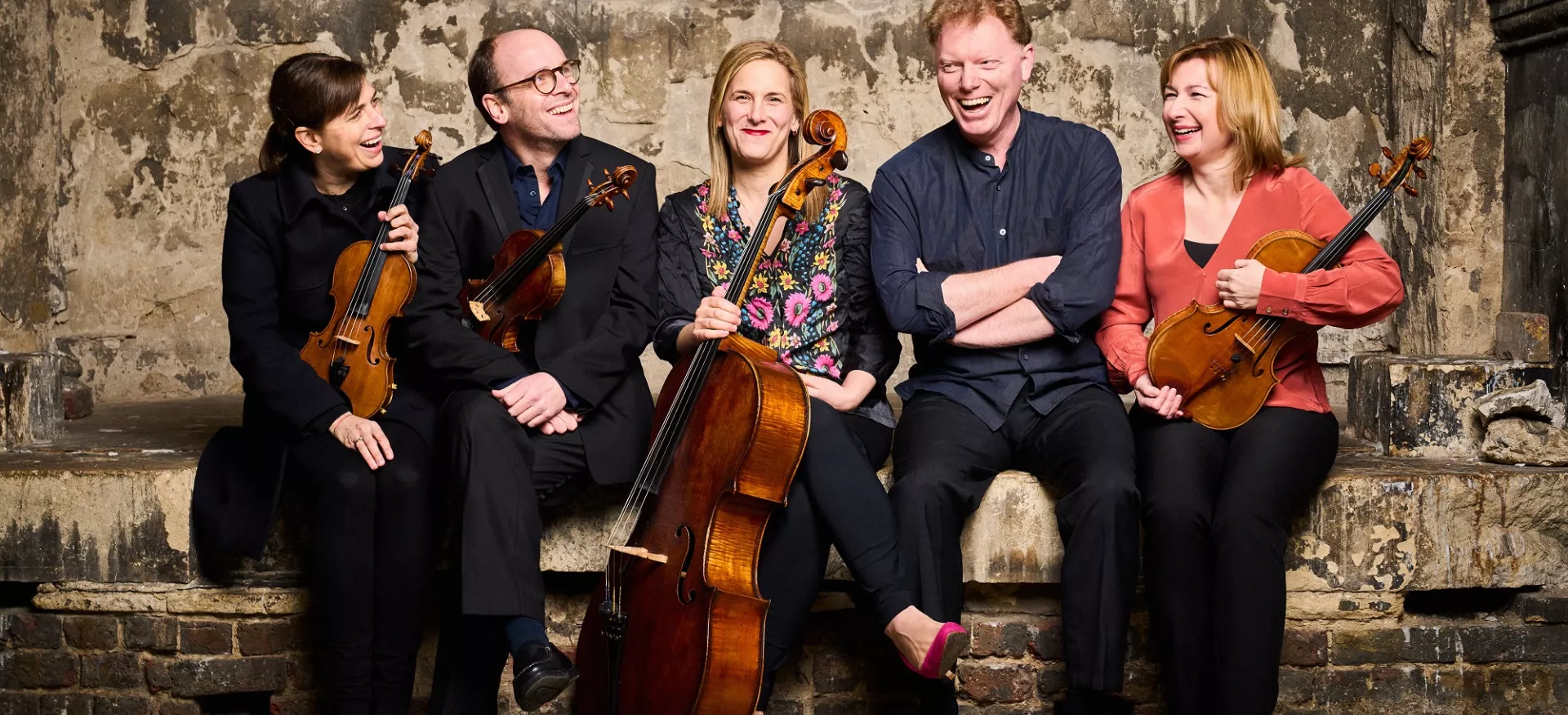 The musicians of Ensemble 360 sit with their instruments 