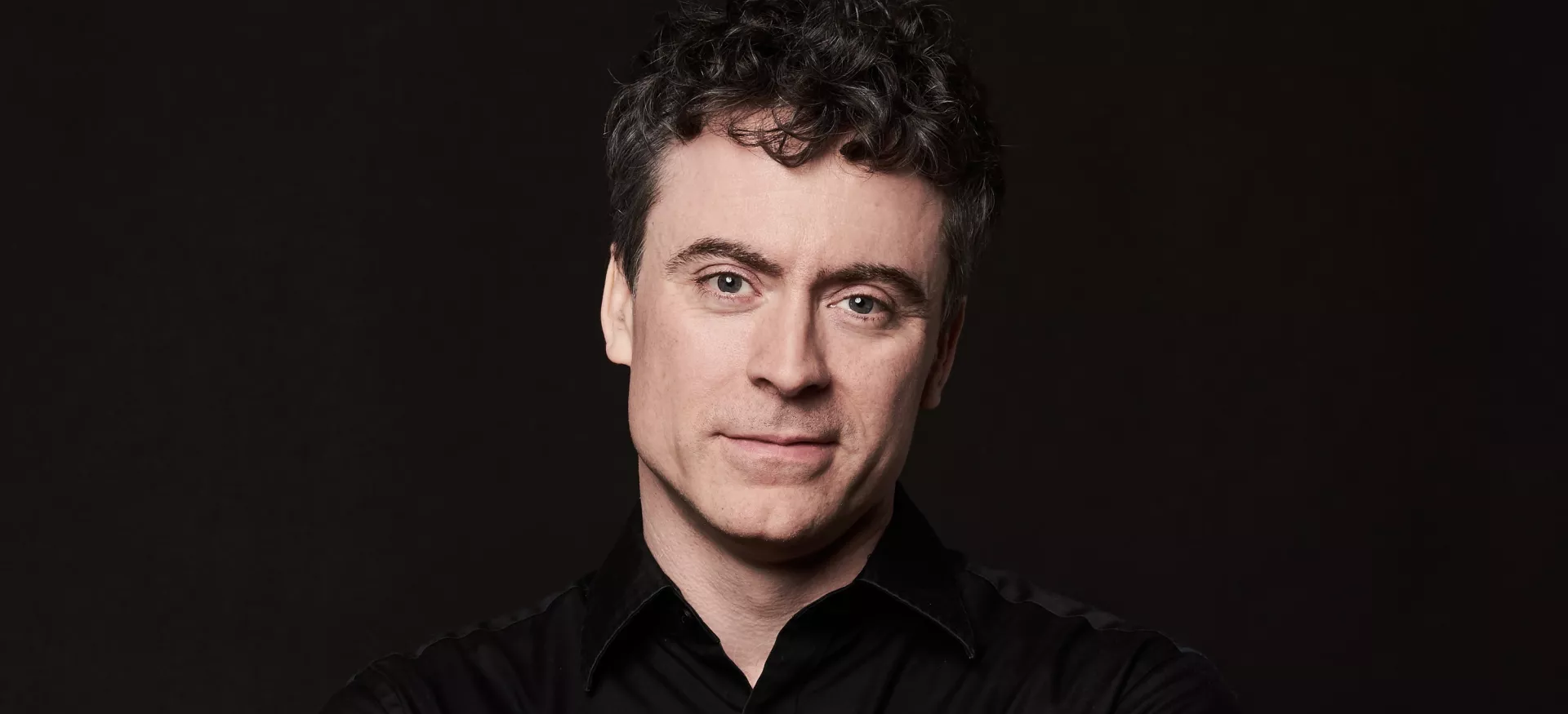 Paul Lewis against a black background,