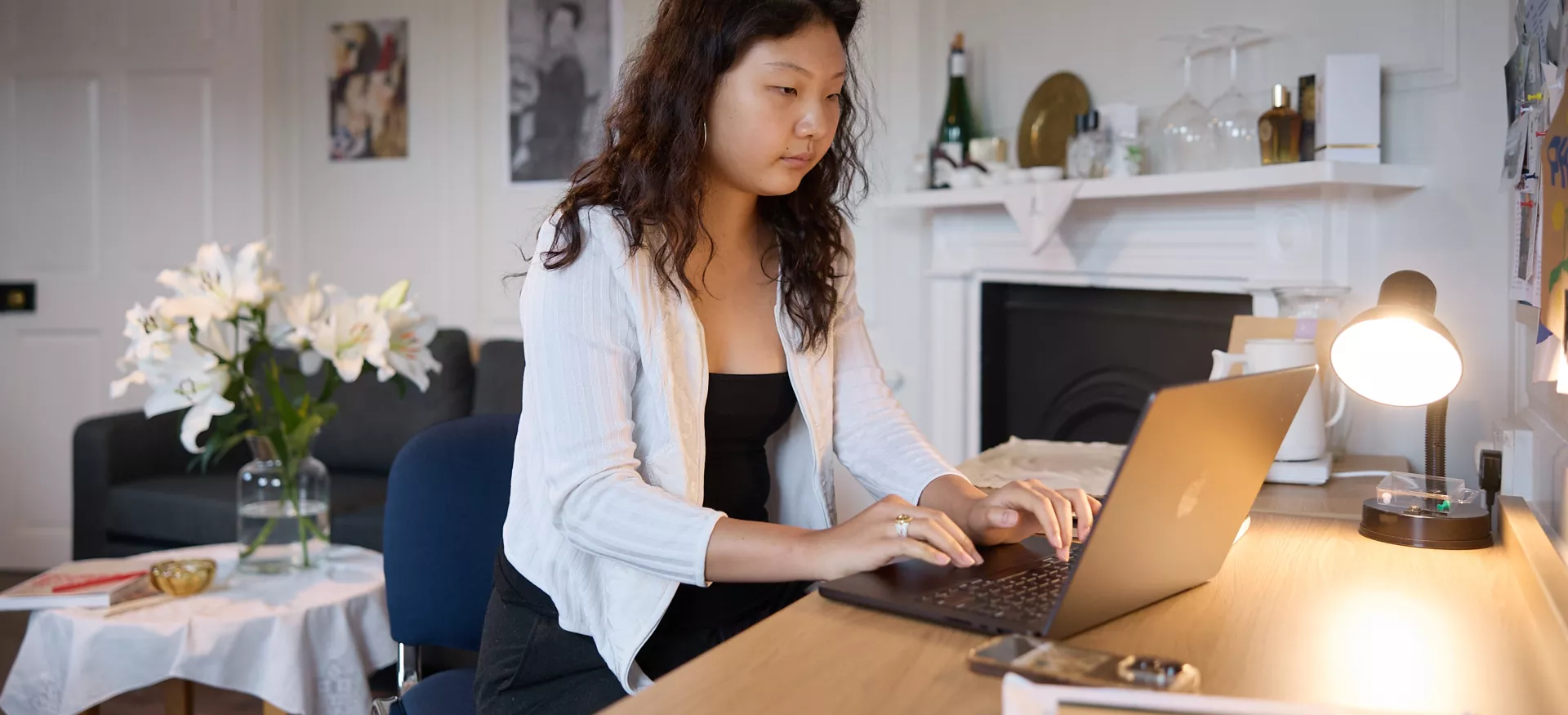 A female student works at her desk in a Trinity College bedroom.