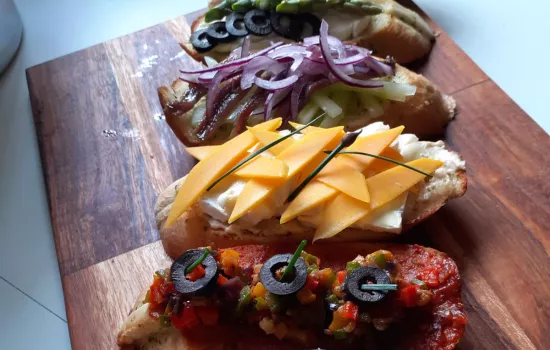 A chopping board with assembled bruschetta on it.