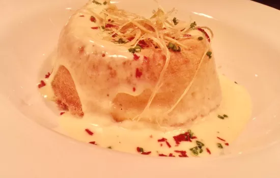 A cheese souffle with sauce on a plate.