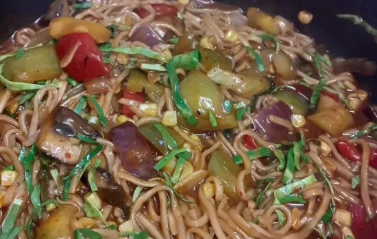 A close-up of Chow Mein noodles with vegetables and sauce.