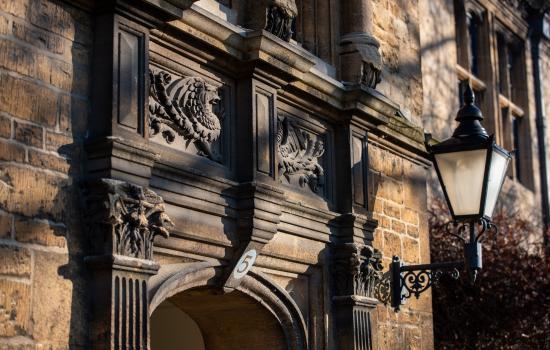 A detail of carving above an entryway in Trinity college, with shadows playing over the surface.