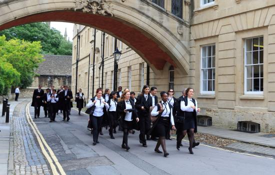 Oxford students dressed for final exams walk through the city.