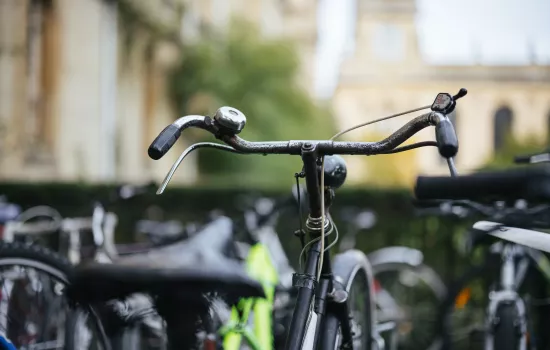 The front of a bicycle in focus, with Trinity's Chapel in the background.