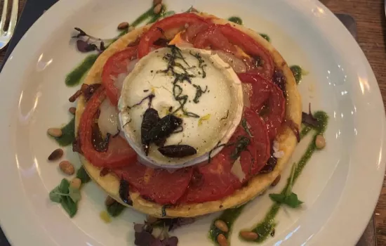 A finished goats cheese tart sitting on a banquet plate.