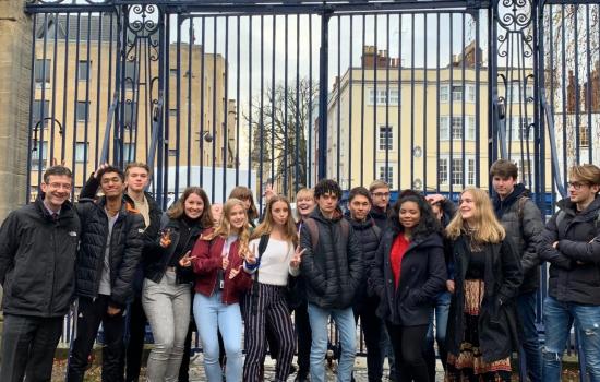 A group of school students stand at the Broad Street Gate inside Trinity College.