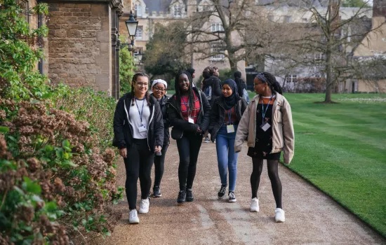 A group of secondary school students chats as they walk around Trinity College.