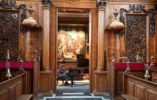 A view inside Trinity College Chapel of a student playing the piano in the Chapel.