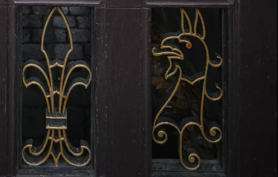 A detail from the back gate to Trinity College, with a gryphon in metal. 