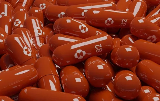a pile of red molnupiravir capsules.