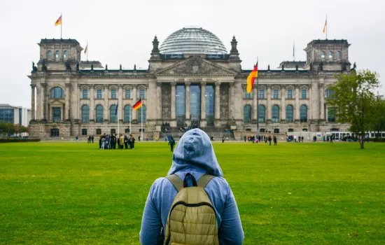 A young woman with backpack looking at Bundestag building in Berlin.