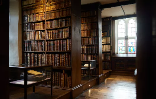 Trinity's Old Library with light shining through a stained glass window.