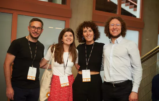 Trinity postgraduate Jo Helme stands at a conference with several colleagues.
