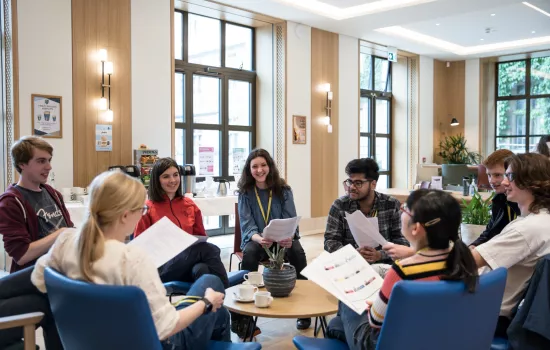 A group of students sit talking over worksheets in the Trinity college cafe.