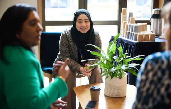 A group of teachers sit in discussion in the Trinity cafe.