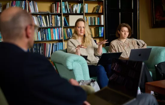 Postgraduates sit in an academic study during a seminar discussion at Trinity.