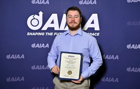 Thomas Cross holds his award