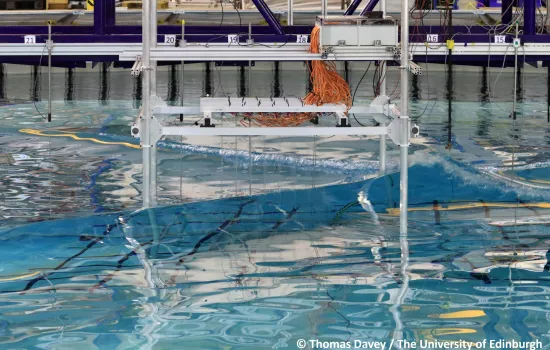 A wave breaking in the FloWave circular basin research facility.