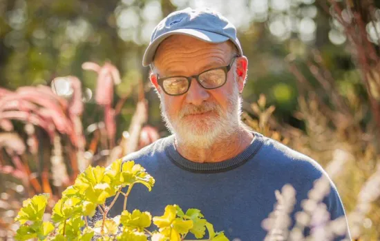 Roy Diblik stands in a sun-filled garden