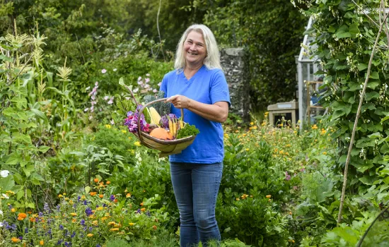 Stephanie Hafferty stands with a basket in a flowering garden