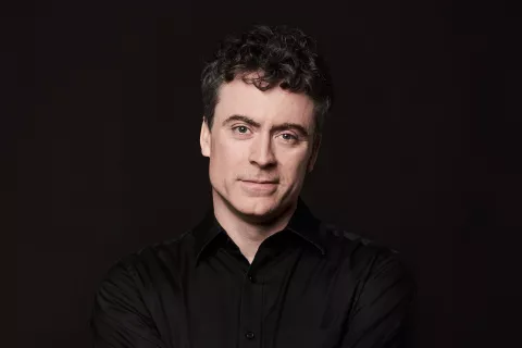 Paul Lewis against a black background,