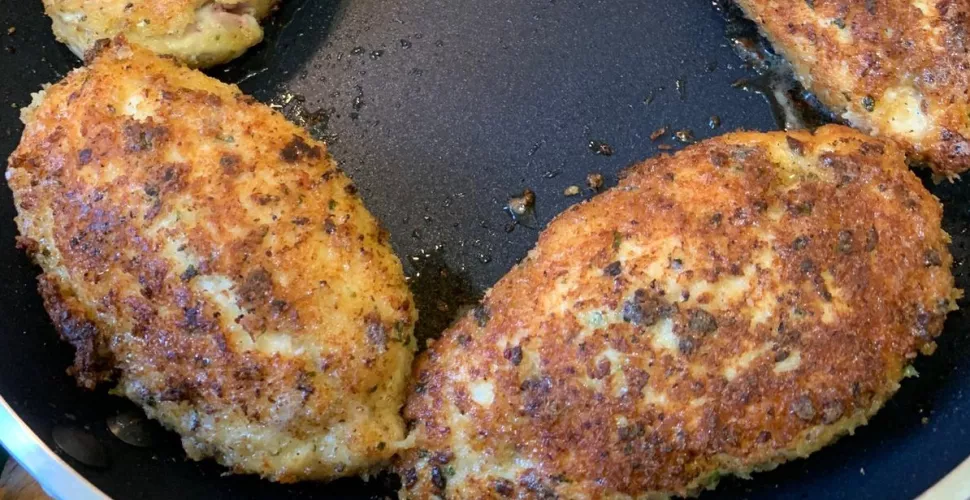 Cooked chicken cordon bleu in a frying pan.