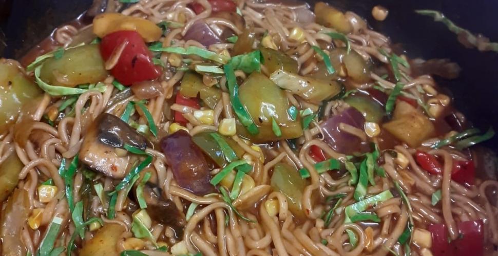 A close-up of Chow Mein noodles with vegetables and sauce.