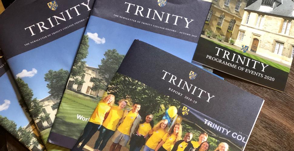 A group of Trinity College alumni publications sit displayed on a table.