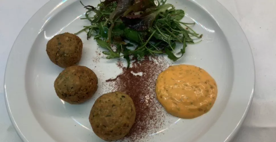 A plate of falafel with spiced mayonnaise and a leaf salad.