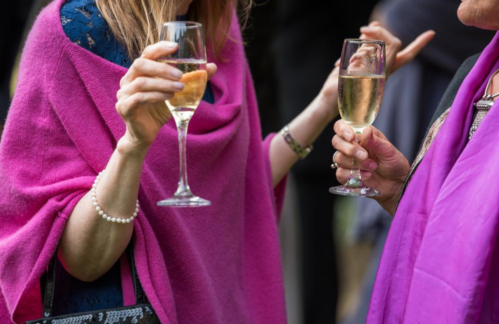 two women holding champagne glasses