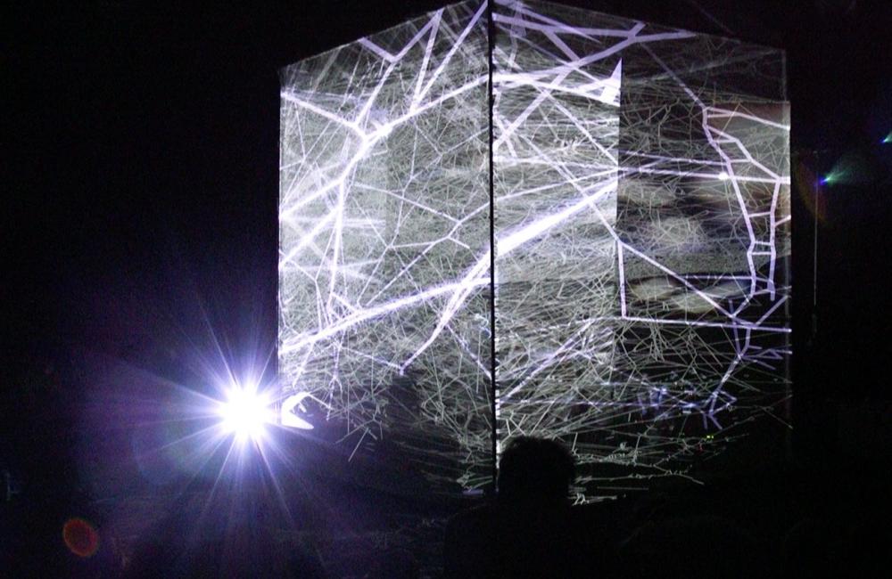 an illuminated cube of spiders webs 