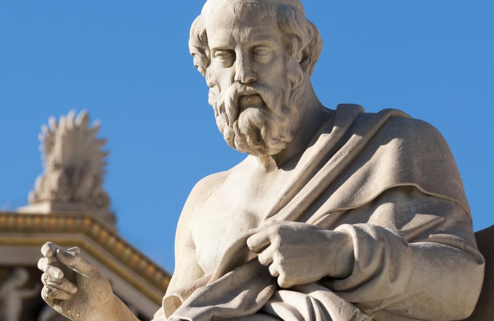 A sculpture of the philosopher Plato seated in thought.
