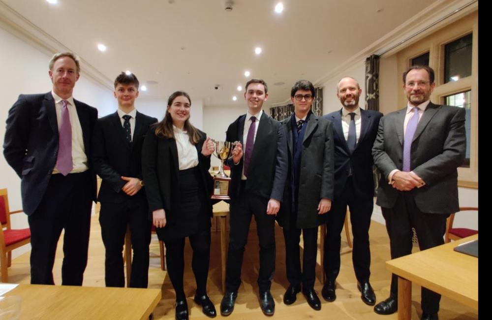 The group of finalists and judges stand after the Intercollegiate Mooting competition final.