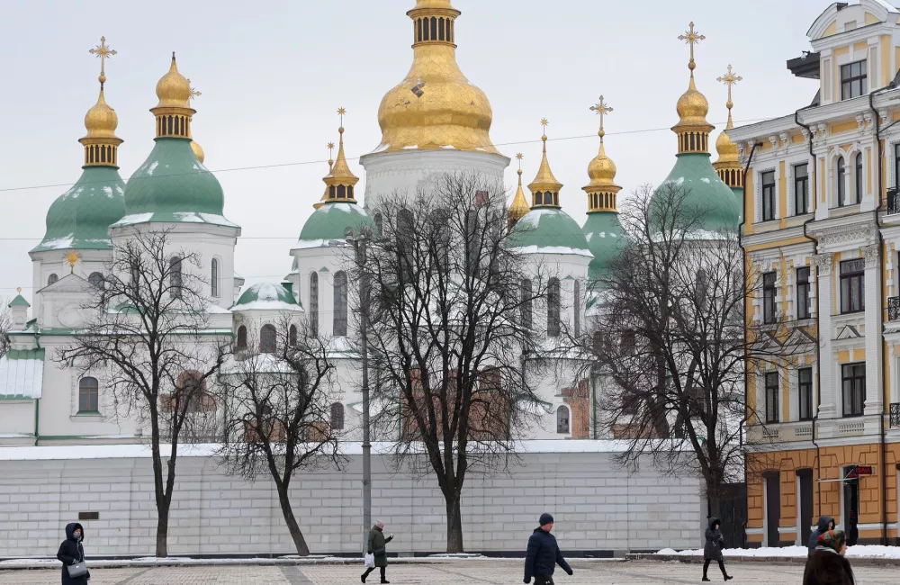 A Ukrainian square with people walking in front of a building.