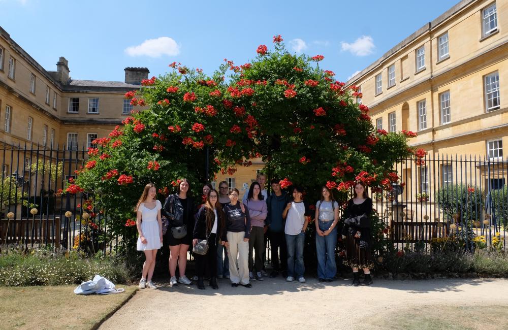 A group of students who participated in the Classics and the Ancient World Summer School stand in front of Trinity's Garden Quad arch.