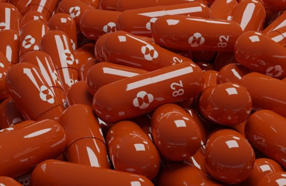 a pile of red molnupiravir capsules.